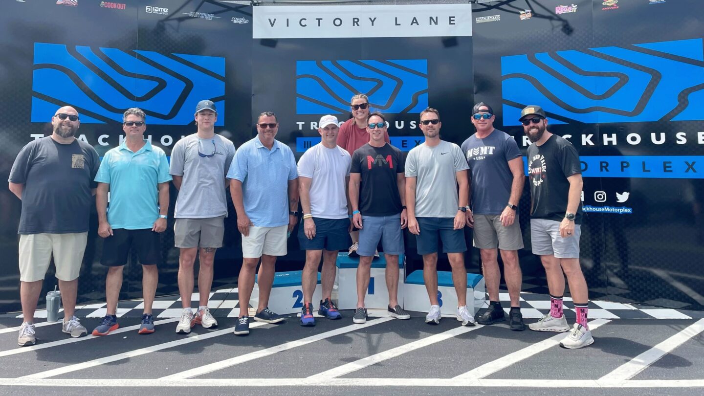 A group of people from a business event who are in the winner's circle.