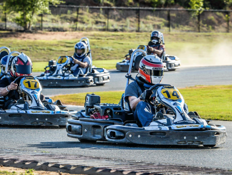 Four karts racing on our track, the drivers are in a turn.
